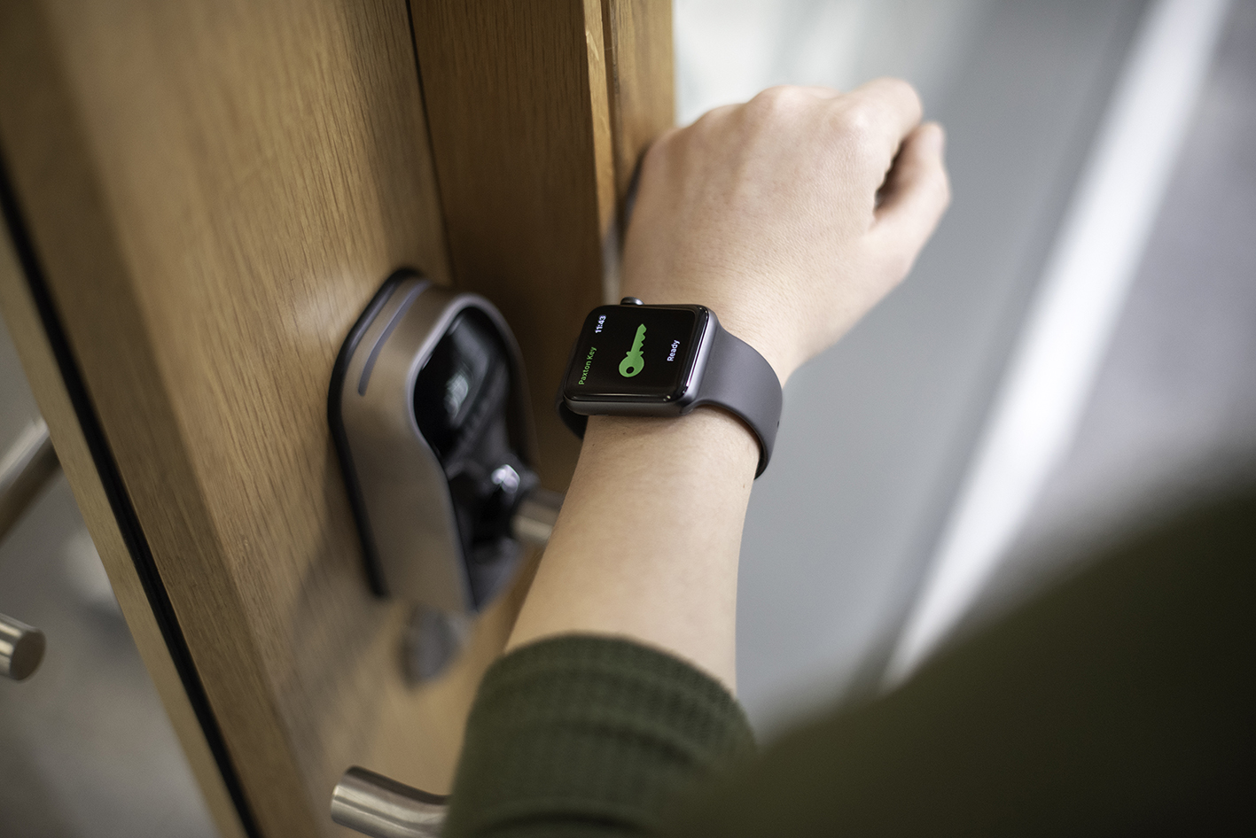 A Smart Watch displays the 'Home' app interface with an option to unlock a door, shown in a modern and minimalistic design.